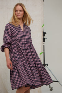 Pink/Navy gingham Irish linen midi dress. Easy fit. Tiered dress. Notch neck topped with tiny ruffle Pockets. Hook and eye at neck. Unlined. Midi length. Long sleeves. Easy fit. 100% Irish linen