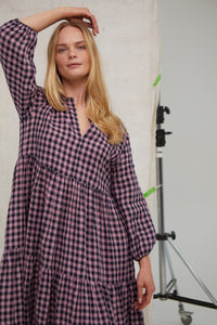 Pink/Navy gingham Irish linen midi dress. Easy fit. Tiered dress. Notch neck topped with tiny ruffle Pockets. Hook and eye at neck. Unlined. Midi length. Long sleeves. Easy fit. 100% Irish linen